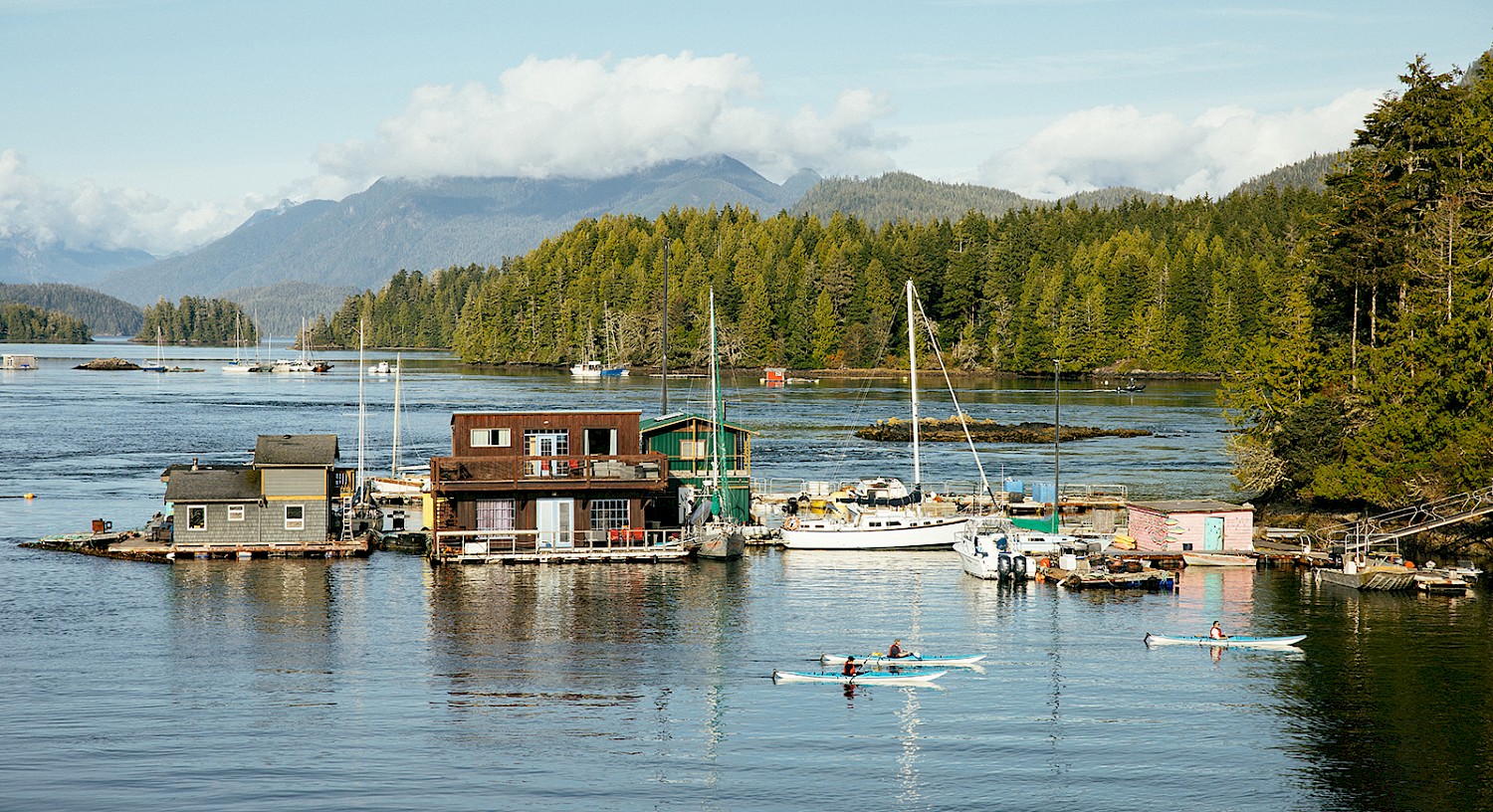 People kayaking to Meares Island with the mountains and islands in the background