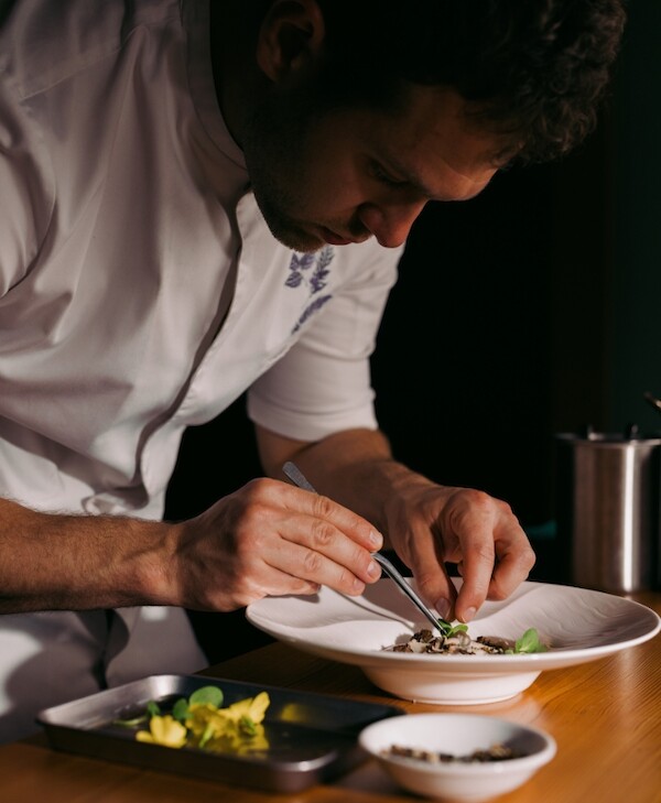 Chef Clayton plating a dish for The Pointe Restaurant with fresh seasonal ingredients