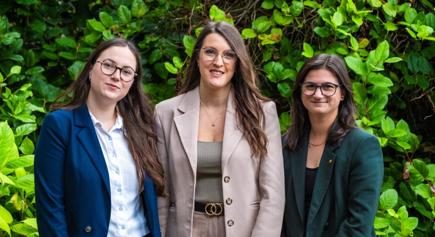 Wickaninnish Inn Special Events team posed in front of Salal bush. Sarah, Caroll-Ann, and Maude stand next to one another in a row.